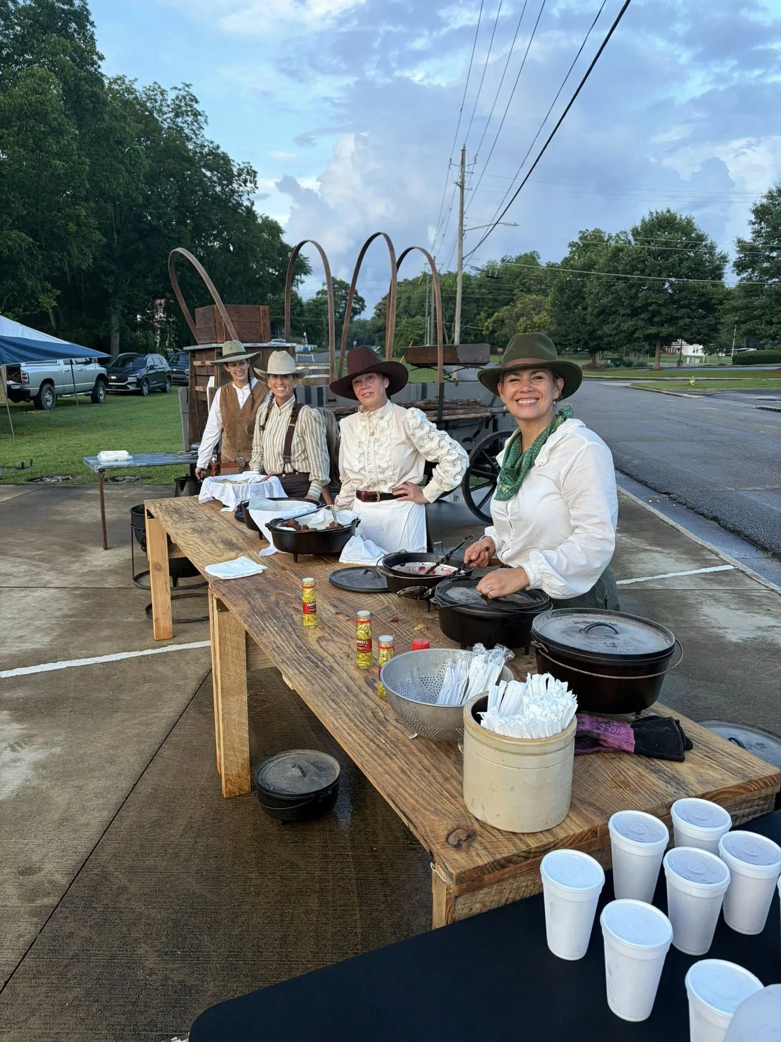 Chuck-wagon cooks in period dress serving supper at a depot event