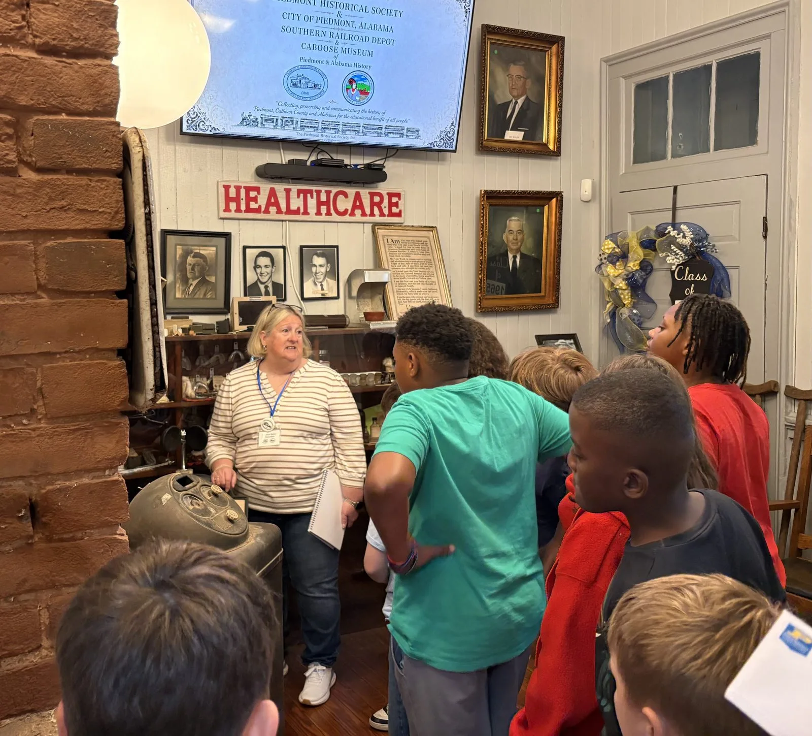 A museum volunteer sharing local history with a visiting class