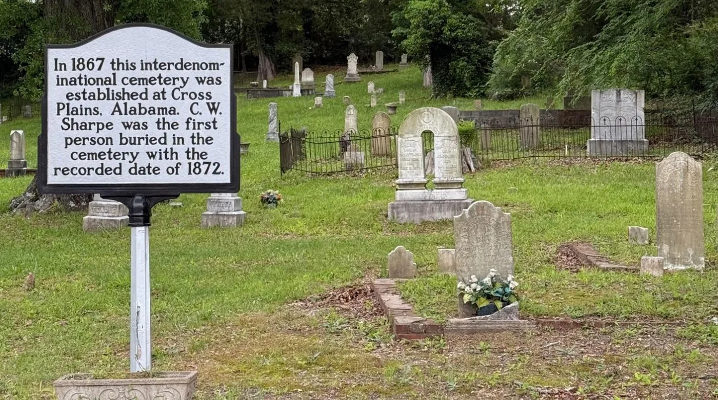 A historic marker in front of weathered headstones at Cross Plains Cemetery