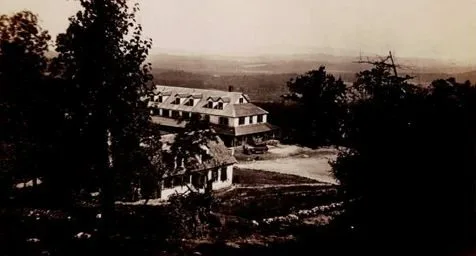 The hotel seen across the mountainside with its detached kitchen building