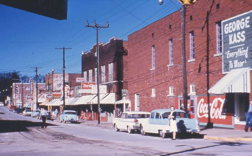 West Ladiga Street in color with 1950s cars and the George Kass clothing store sign
