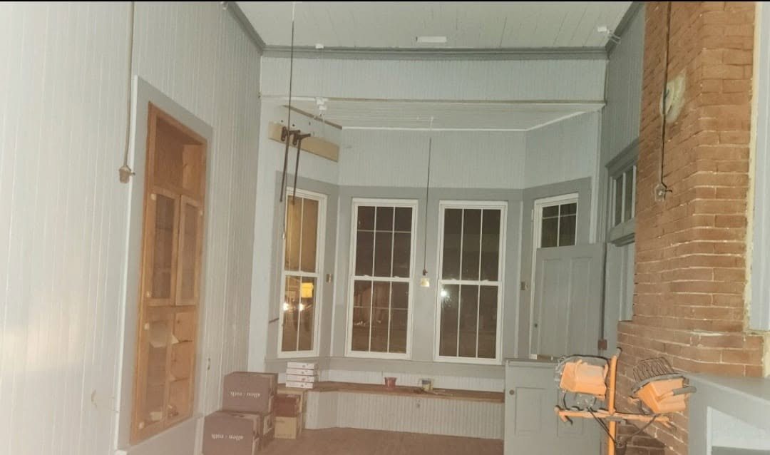 A depot room mid-restoration — bare walls, work lights, and boxes
